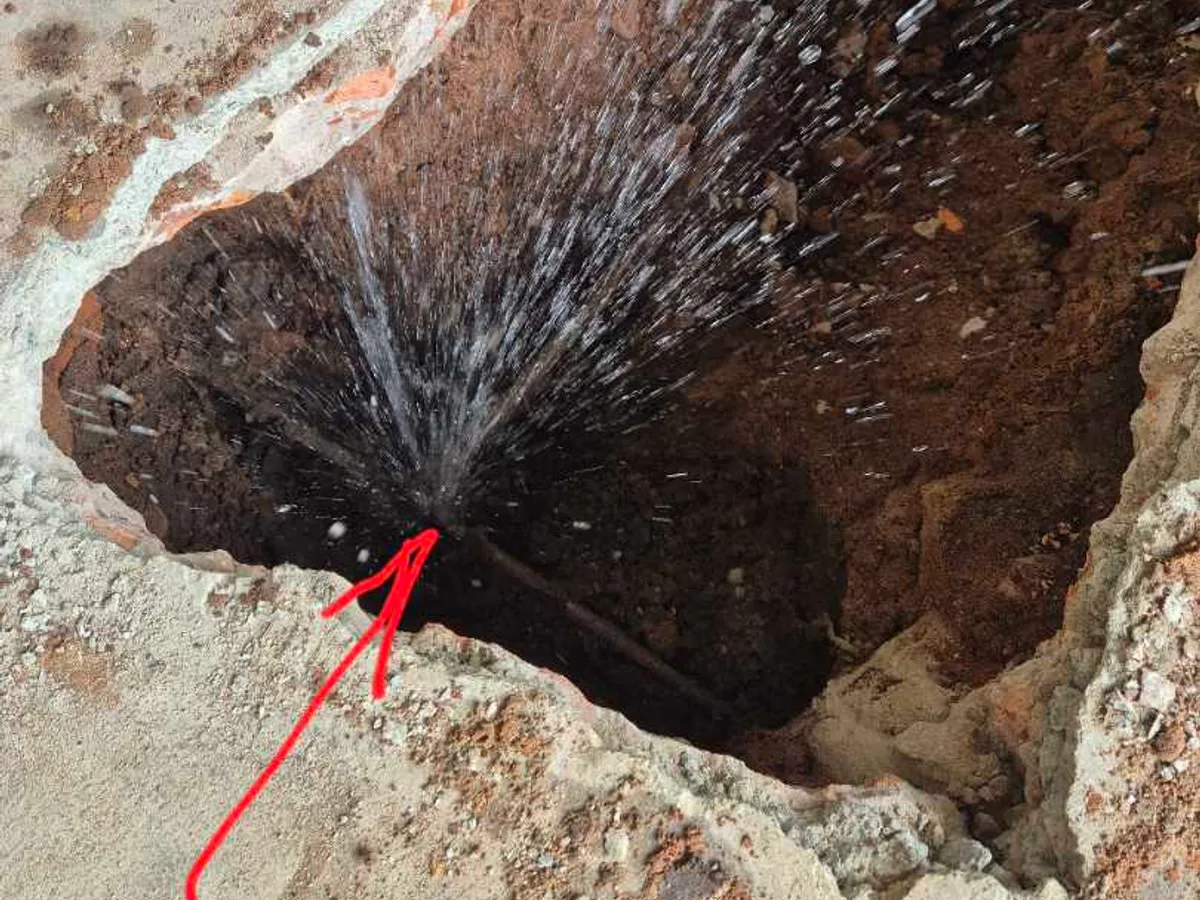 Water spraying from the burst copper supply pipe once the garage floor had been opened up