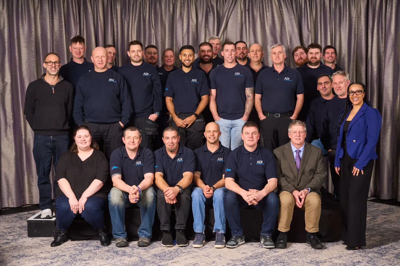 The ADI Leak Detection team photographed together: leak investigation engineers in ADI polo shirts alongside the office and leadership team