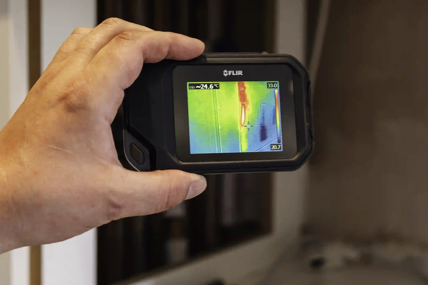 A thermal imaging camera in use, showing a cold patch spreading across a floor